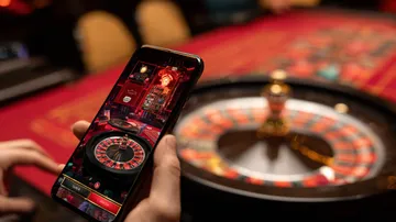 উৎসবের মুহূর্তে ঐতিহ্যবাহী পোশাক পরা এক আনন্দিত নারী তার স্মার্টফোন ব্যবহার করছেন, যা দেখায় BAGI200 অ্যাপ কীভাবে দৈনন্দিন জীবনের সঙ্গে সহজে মানিয়ে যায়।